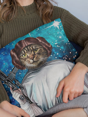 A person in a green sweater holds a Custom Star Wars Princess Leia Pet Cushion featuring a cat as Leia with buns and blaster, set against a starry background—an ideal gift for pet lovers.